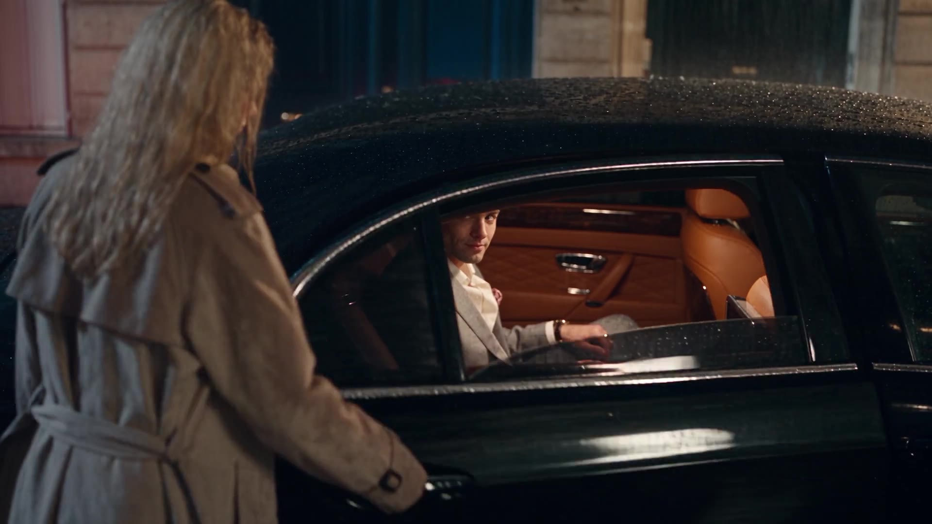 Emma meets a man through a car window on a rainy Paris evening — a still from the film